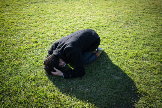 芝生の上に崩れ落ちた男性