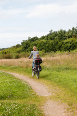 Fototapeta premium Woman with child behind cycling away in beautiful nature