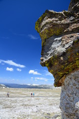 A big rock face of Colorado mountain looking down people