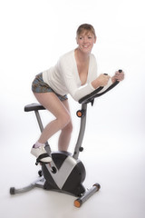 Fototapeta na wymiar Middle aged woman working out on an exercise bike - 2016