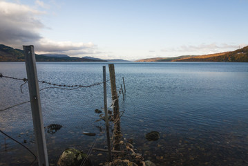 An old barbed wire fence leading into Loch Rannoch, Perth and Kinross, Scotland