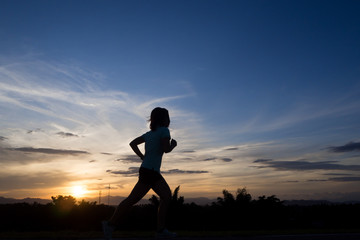 silhouette running woman on twilight sky in the evening.
