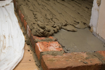 Indoor DIY project: building fireplace in the house: laying bricks. Selective focus