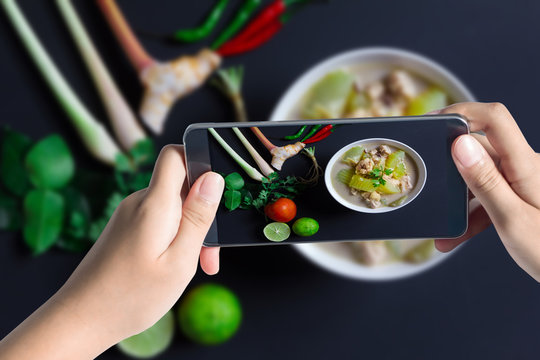 Taking photo of Chicken and coconut milk soup on black backgroun