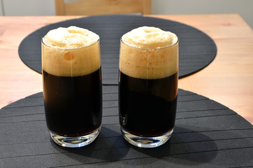 two glasses of black beer on the table detail photography