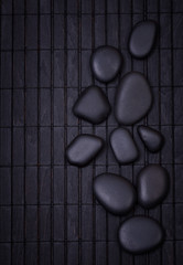 Black zen stones on a wooden black painted  dark surface