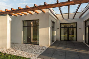 Concrete, loft house with wooden stakes on roof