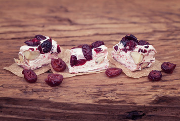 Soft nougat topped with forest fruits on rustic wood