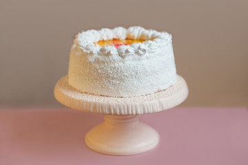 White cake on stand with gray background, horizontal