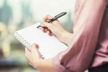 Hands writng in notepad