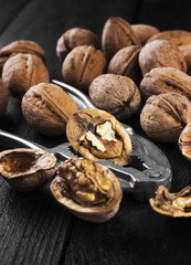 Walnut kernels and whole walnuts on wooden background