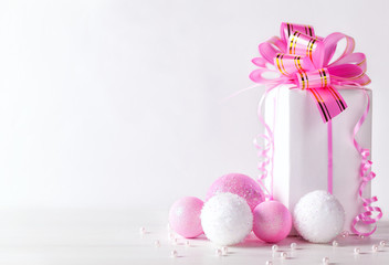 White greeting card with copy space for christmas or new year with a wrapped gift and pink ball.