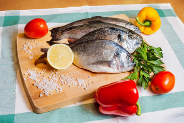 Fresh fish on wooden cutting board