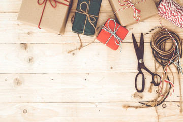 Hand crafted Christmas gift box on white wooden background and tool. vintage color tone