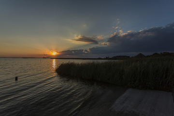 Sunset & clouds on water's edge with grasses, Outer Banks, NC