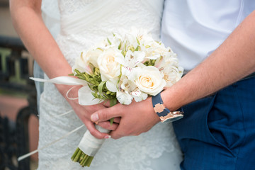 Obraz na płótnie Canvas Hands newlyweds with a bouquet
