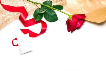 Border of fresh red roses with red ribbon and decoration paper i