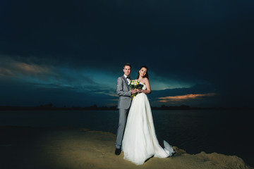 Newlyweds on the river bank at night