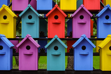 Stacked rows of colorful birdhouses. New multicolored nesting boxes in vintage style.