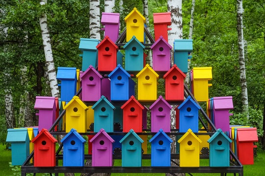 Stacked rows of colorful birdhouses. New multicolored nesting boxes in vintage style.