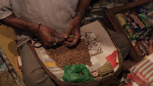 MS TD Senior man rolling cigarettes / India