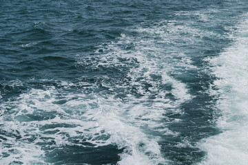 Close up foam wave on sea from boat. nature background texture for graphic resource.