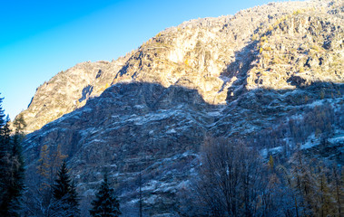 Fototapeta premium Mountain landscape with snow and snow-covered trees. Mountains in winter with colorful trees
