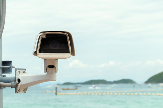 closed-circuit camera ( cctv ) security with blurry background view of sea and hill .