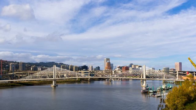Time lapse movie of white clouds and blue sky over downtown city auto traffic on Marquam bridge and Tillikum Crossing over Willamette River in Portland Oregon 4096x2304 4k uhd