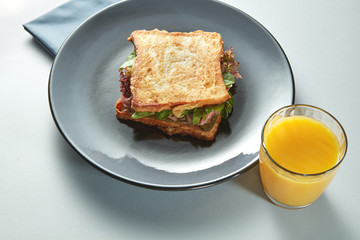 plate with grilled sandwich and orange juice