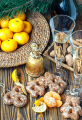 Vintage Christmas Composition with nuts, tangerine, pine cones, bells and glasses of champagne on wooden background