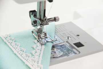 The sewing on the sewing machine turquoise fabric