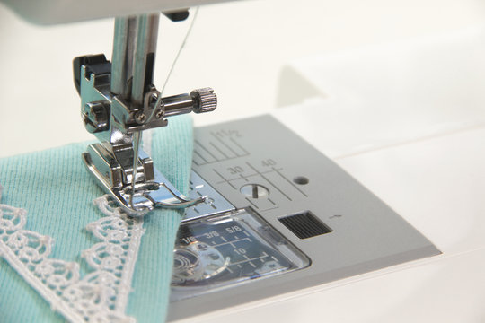 The sewing on the sewing machine turquoise fabric