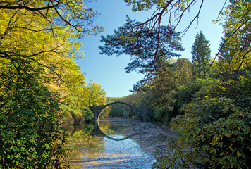 Arch Bridge in Kromlau, Saxony, Germany. Autumn in Park. Rakotz bridge in Kromlau