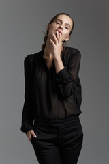 Fashion style model in black shirt and pants posing in the studi