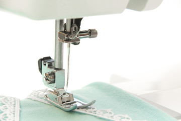 The sewing on the sewing machine turquoise fabric