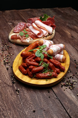 Food tray with delicious salami, pieces of sliced ham, sausage, tomatoes, salad and vegetable - Meat platter with selection