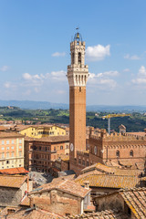 Fototapeta na wymiar Siena, Italy. Torre del Mangia (Tower Beefeaters) and the medieval Commune Palace (Palazzo Publico), the former royal residence of the 12-16 centuries, in Piazza del Campo