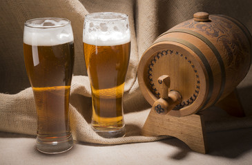 Wooden barrel with beer glasses on canvas background