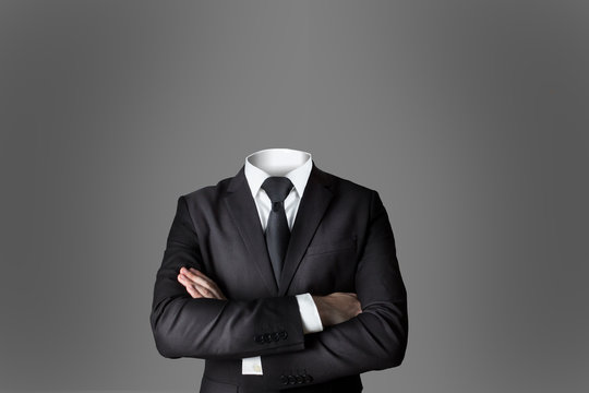 businessman without head crossed arms grey background