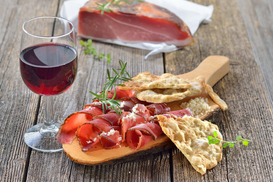 S&uuml;dtiroler Speck mit frischem Meerrettich, Sch&uuml;ttelbrot und regionalem Rotwein - South Tyrolean bacon with fresh horseradish, crispy flatbread and local red wine