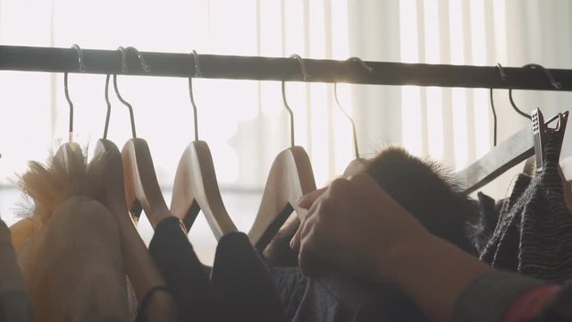 Close-up: a hanger for clothing. Clothes hangers. Designer clothing collection. Designer with a ready collection. Sunlight between hangers for clothes. Solar Design Studio. Atelier, bathed sunlight.