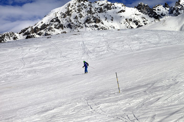 Naklejka na ściany i meble Skier on ski slope at sun winter day