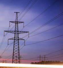 High voltage power tower and silhouette power lines sunset.