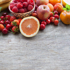 Summer fruits and berries on a dark wooden table, with space for text, selective focus