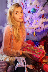Young caucasian woman posing with Christmas gifts in domestic i