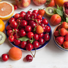 Summer fruits and berries on a white table, with space for text, selective focus