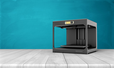 Black 3d printer standing on white wooden table with blue background.
