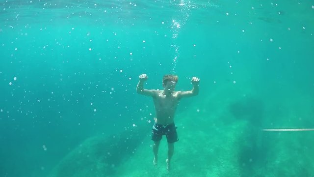 SLOW MOTION, UNDERWATER: Exhausted and unexperienced swimmer drowning in ocean