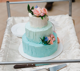 Wedding cake in white and blue in marriage banquet, adorned with flowers